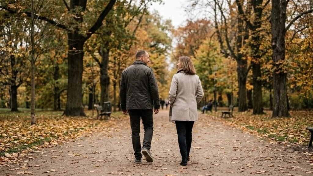 Couple walking side by side on a park path while talking