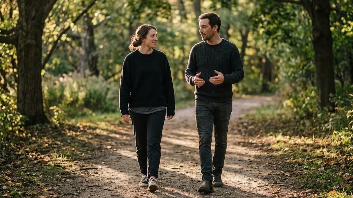 Couple walking side by side on a tree-lined path